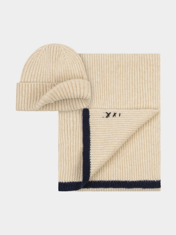 Beige knit hat and scarf set with navy trim on a light gray background
