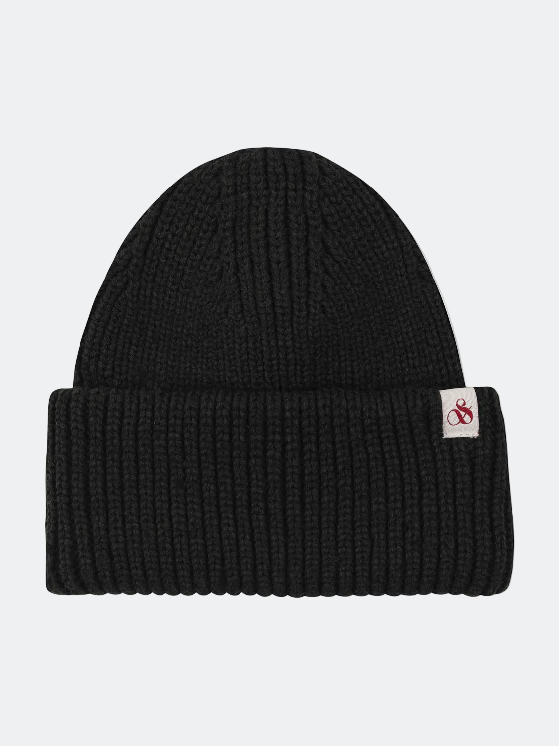 Black knit beanie with a brand label on a white background