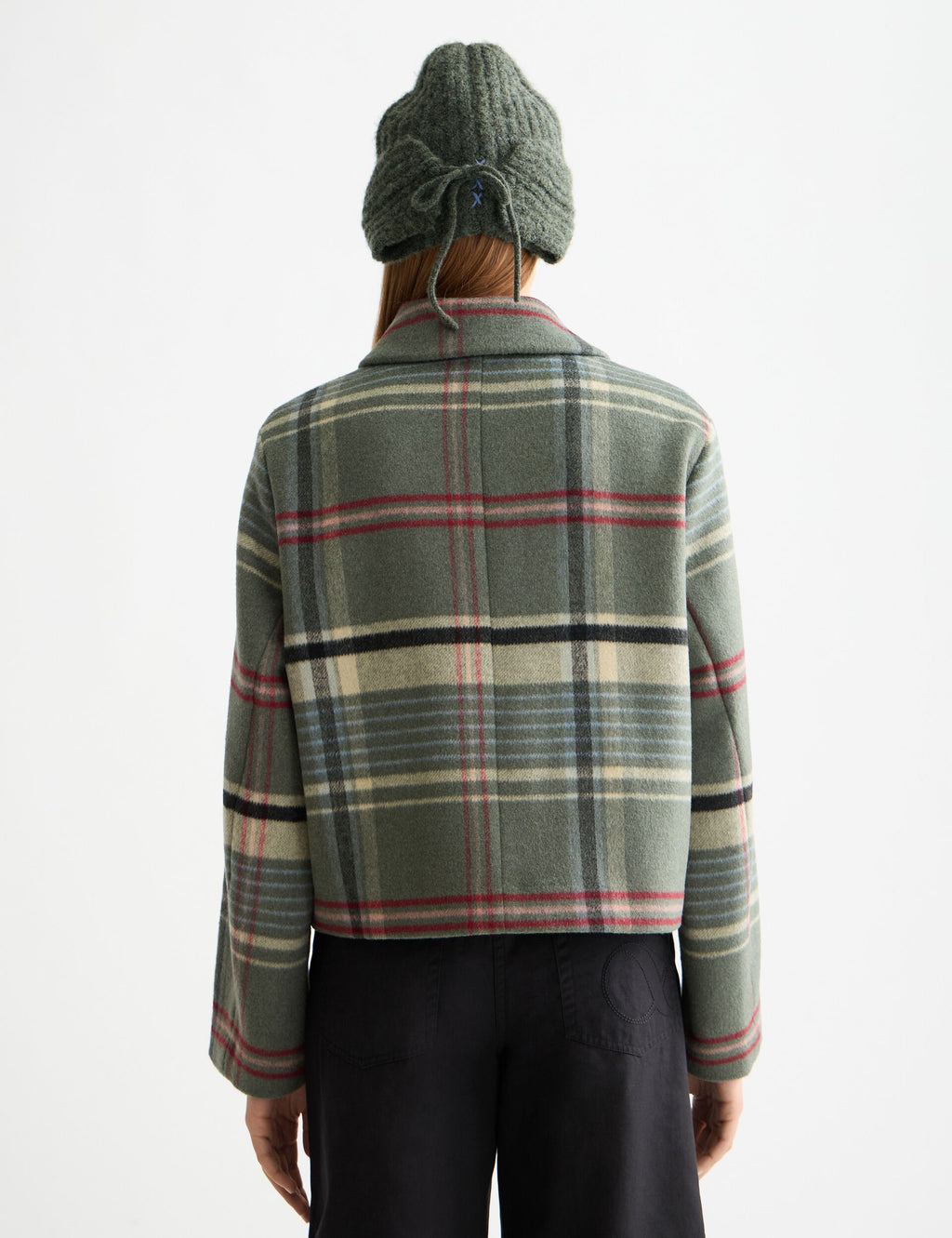 Person wearing a green plaid jacket on a white background