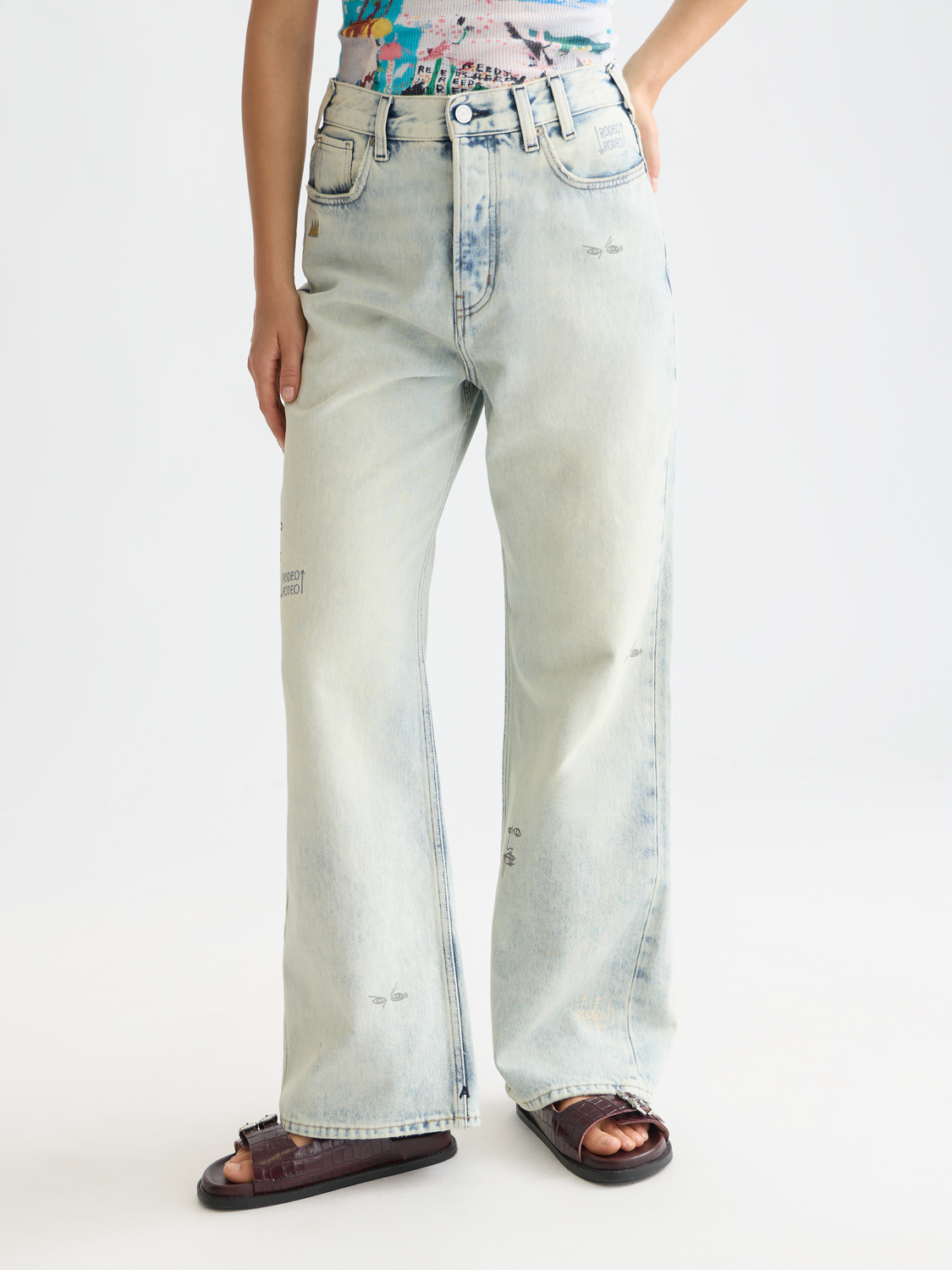 Person wearing light blue jeans on a white background