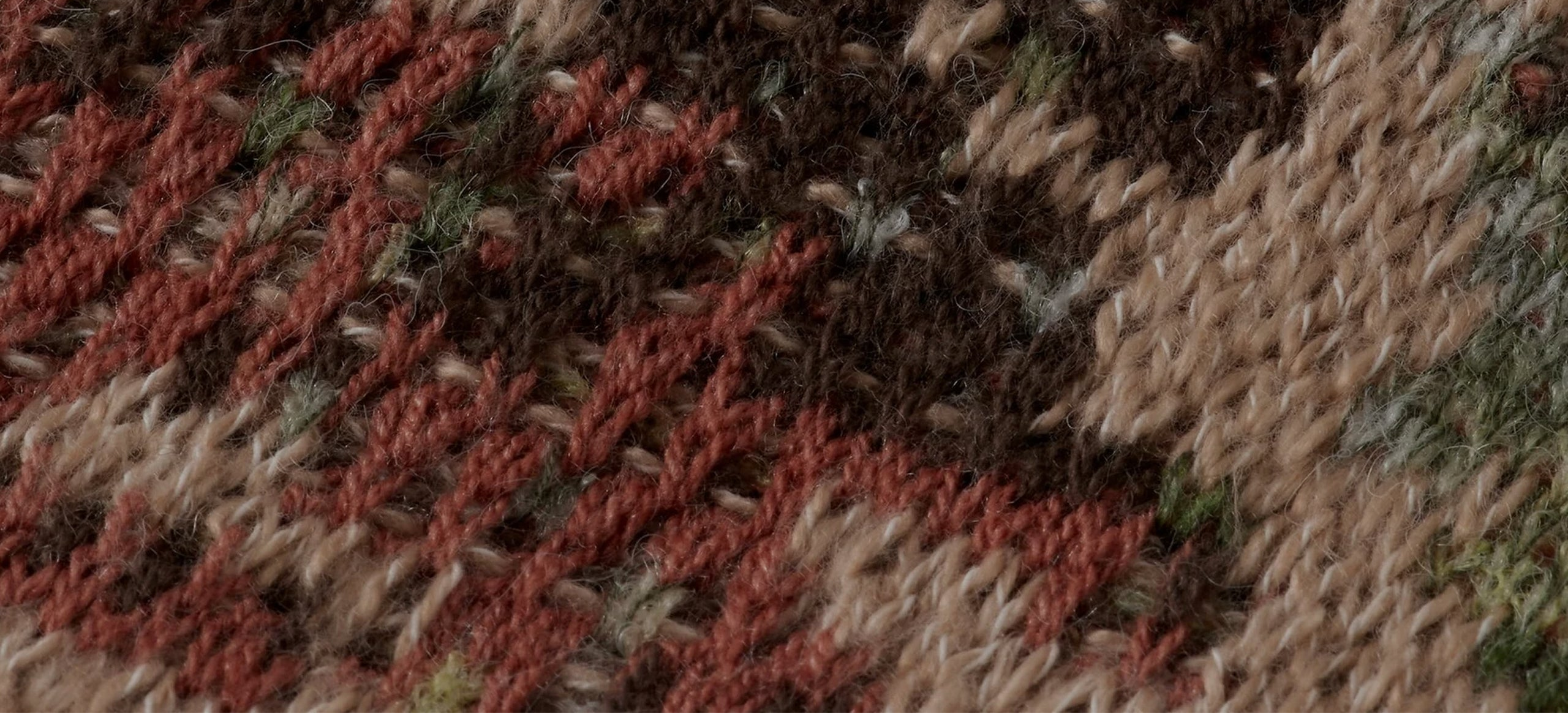 Close-up of a textured fabric with brown, red, and beige colors.